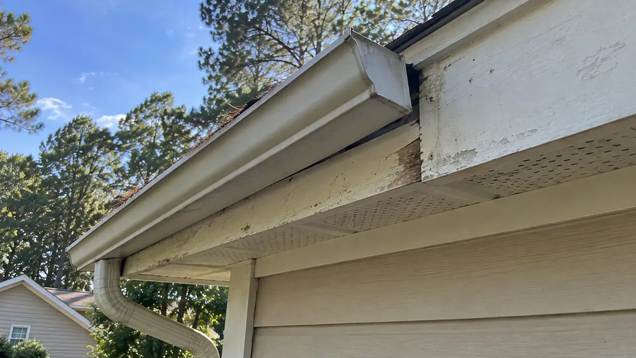 A gutter pulling away from the fascia board at one end of a roofline.